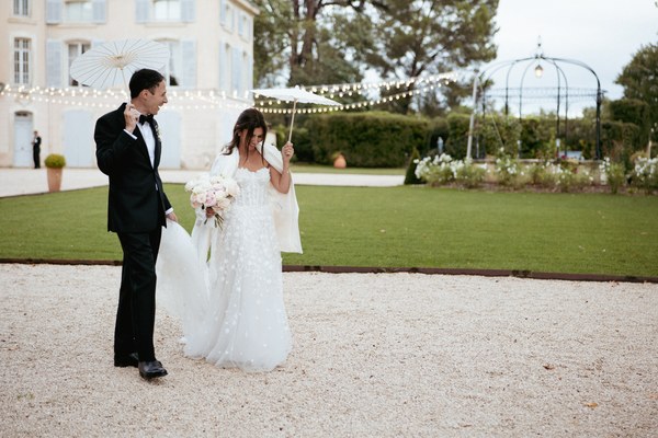 Couple marche parc guirlandes château - mariage Provence